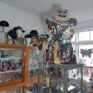 oude hoedjes, versierde torso met kettingen en broches in TextielHuismuseum